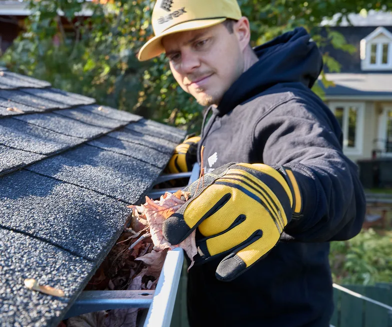 Installer setting a seamless gutter at the roofline